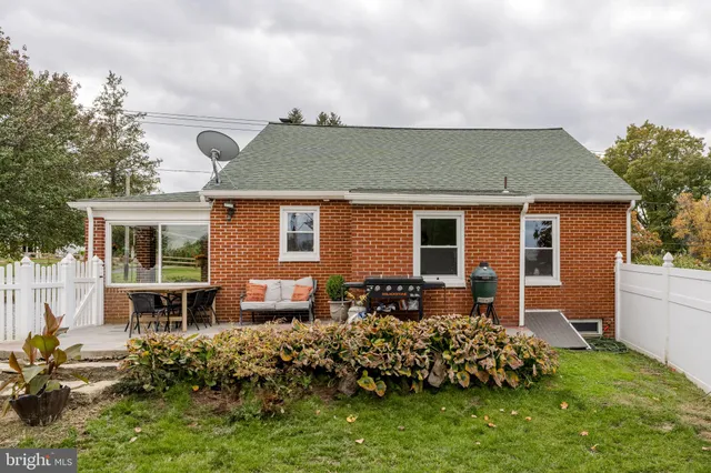 a backyard of a house with a table and chairs