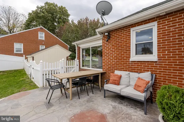 a backyard of a house with barbeque oven table and chairs