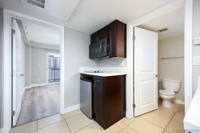 a bathroom with a granite countertop sink a toilet a mirror and vanity