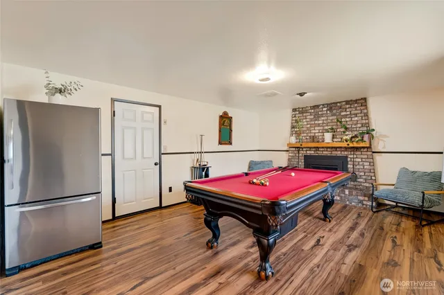 a room with furniture pool table wooden floor and windows