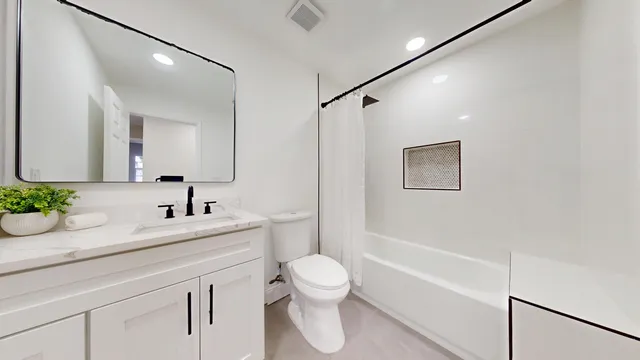 a bathroom with a granite countertop sink a toilet and a mirror
