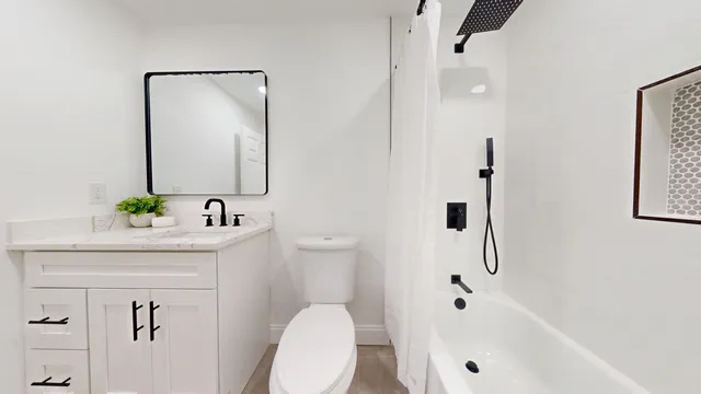 a bathroom with a bathtub a sink a toilet and a mirror