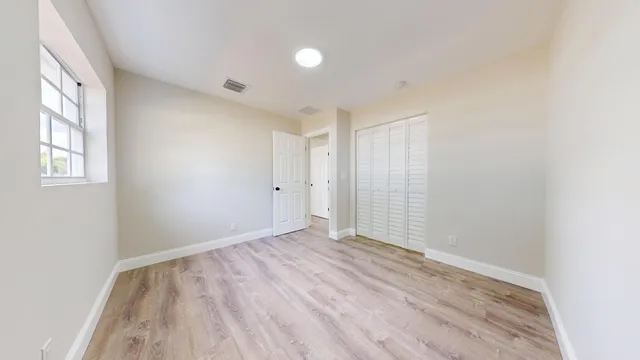 wooden floor in an empty room with a window