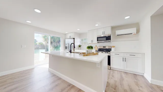 a kitchen with white cabinets and stainless steel appliances