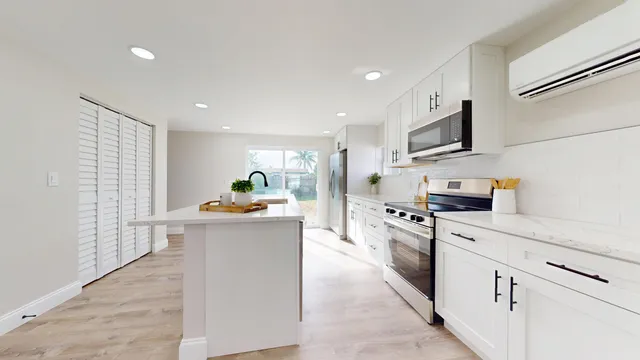 a kitchen with white cabinets and appliances