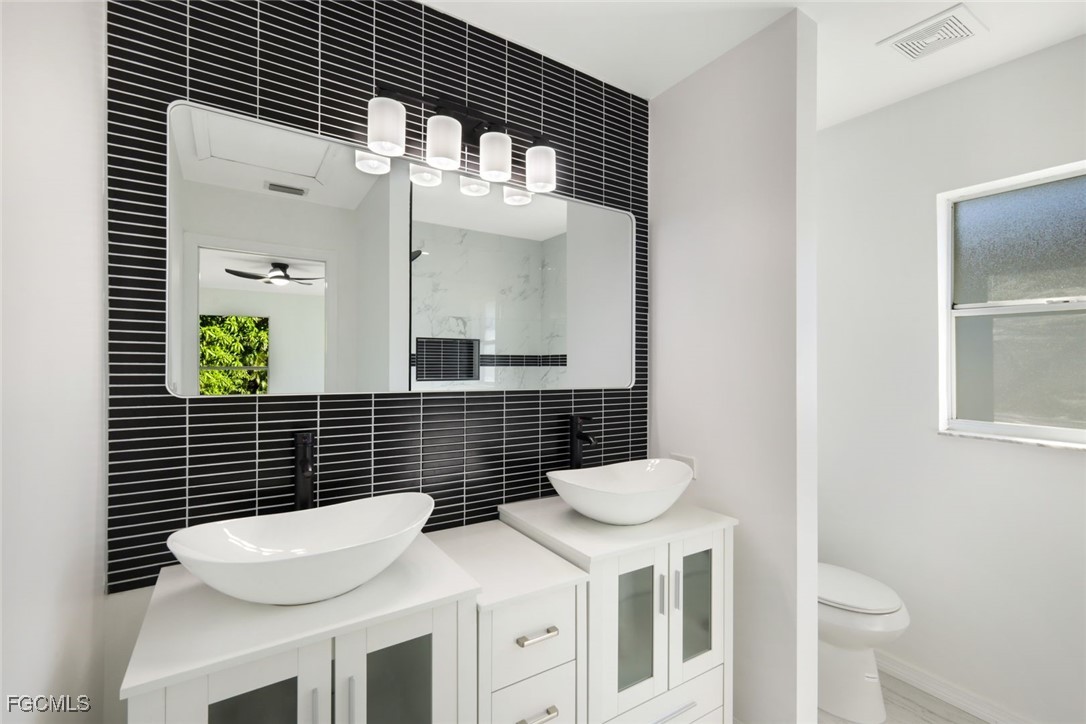 2519 Southwest 30th Street Cape Coral, FL 33914 - Photo 14 of 23 a bathroom with a toilet a sink and mirror