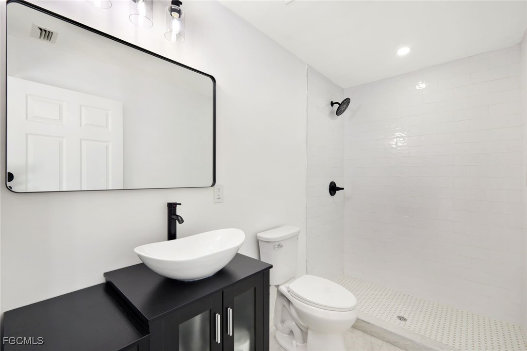 2519 Southwest 30th Street Cape Coral, FL 33914 - Photo 17 of 23 a bathroom with a sink toilet a mirror and vanity