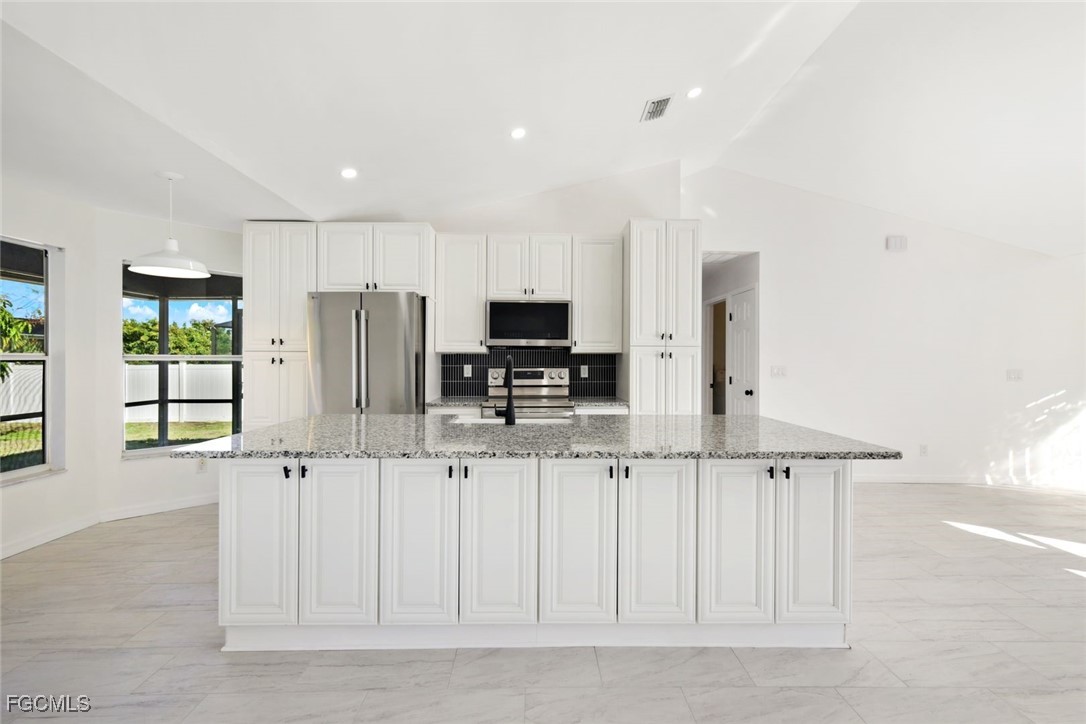 2519 Southwest 30th Street Cape Coral, FL 33914 - Photo 7 of 23 a kitchen with stainless steel appliances a refrigerator and white cabinets
