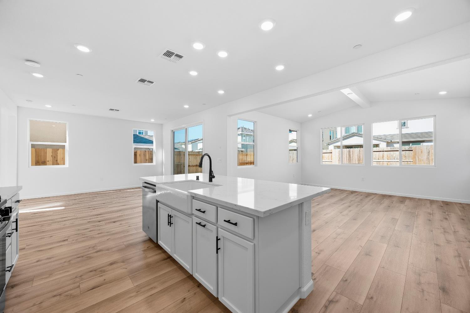 4401 Canyon Coral Way Rancho Cordova, CA 95742 - Photo 11 of 23 a large white kitchen with kitchen island a sink appliances wooden floor and a window