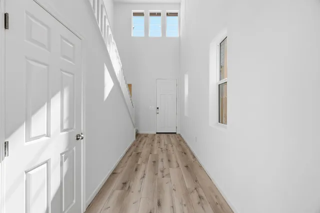 a view of a hallway with wooden floor and entryway