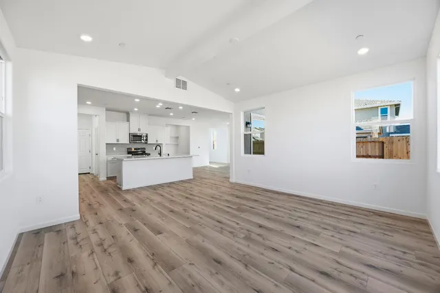a kitchen with stainless steel appliances a sink stove and wooden floor