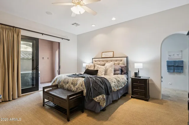 a spacious bedroom with a bed and a chandelier