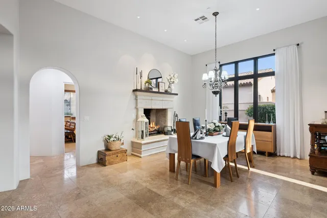 a dining room with furniture a fireplace and a chandelier