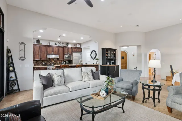 a living room with furniture kitchen view and a chandelier