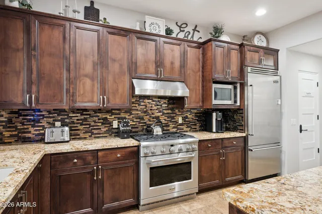 a kitchen with stainless steel appliances a stove a sink and a refrigerator