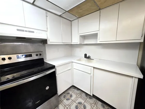 a kitchen with a stove and white cabinets