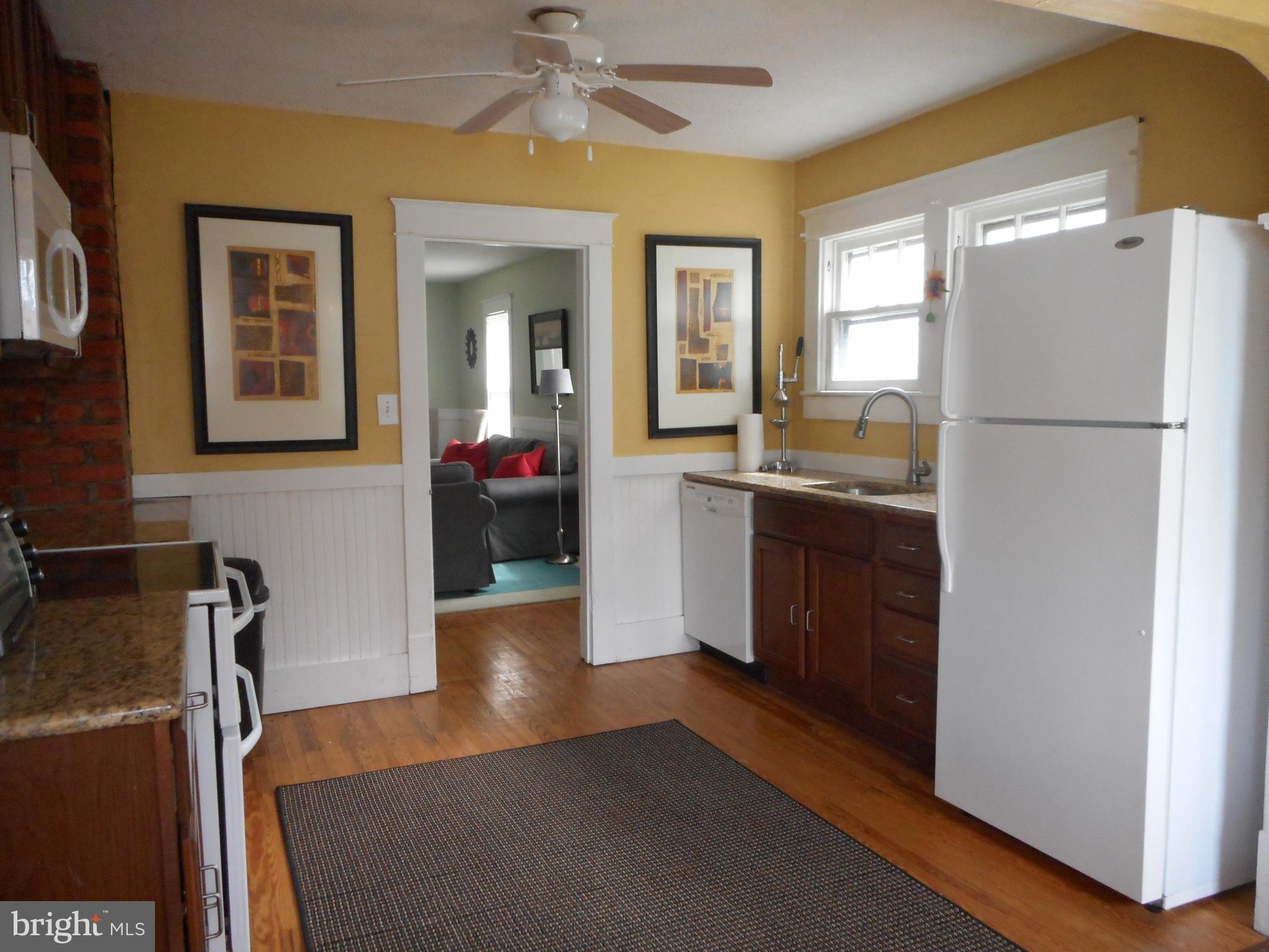 105 Hiawatha Road Cambridge, MD 21613 - Photo 4 of 15 a kitchen with a refrigerator a sink and dishwasher with wooden floor