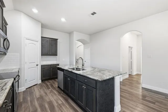 a kitchen with stainless steel appliances granite countertop a sink stove and refrigerator