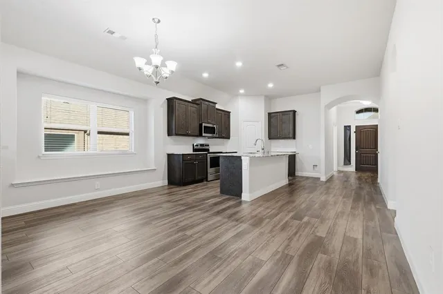 a view of a kitchen with a sink a microwave and cabinets