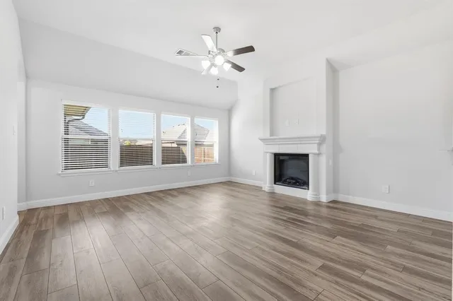 wooden floor fireplace and windows in an empty room