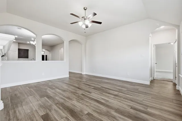 a view of a livingroom with wooden floor and a ceiling fan