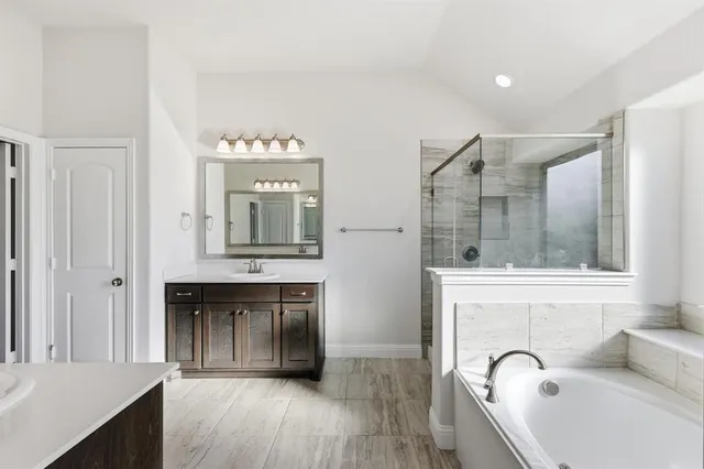 a spacious bathroom with a mirror a bathtub and shower