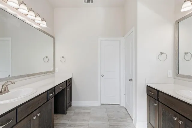 a spacious bathroom with a double vanity sink and a mirror
