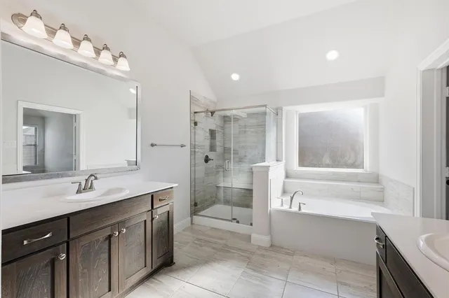 a spacious bathroom with a tub sink shower and mirror
