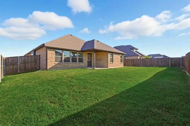 a view of a house with a big yard and large trees
