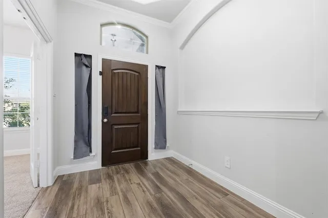 a view of empty room with wooden floor