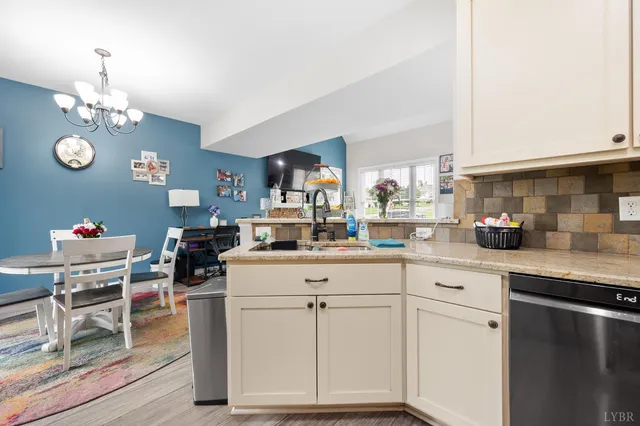 a kitchen with white cabinets and sink