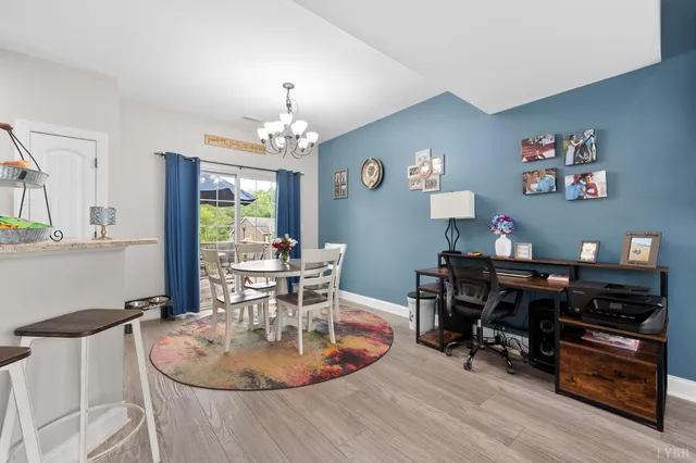 a dining room with wooden floor and a chandelier