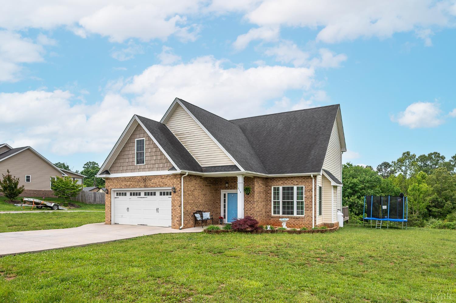 314 Cooper Way Evington, VA 24550 - Photo 2 of 44 a front view of a house with a garden and trees