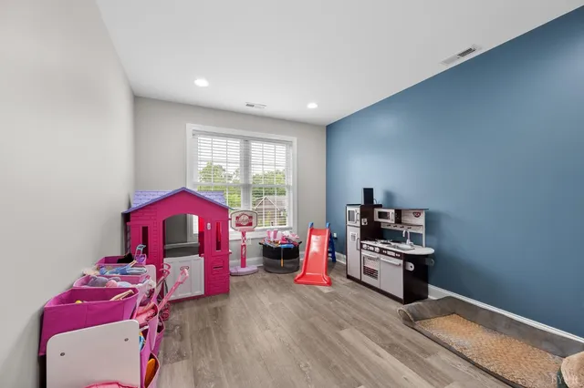 a living room with furniture a flat screen tv and a window