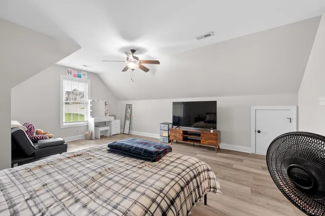 a bedroom with furniture and a flat screen tv