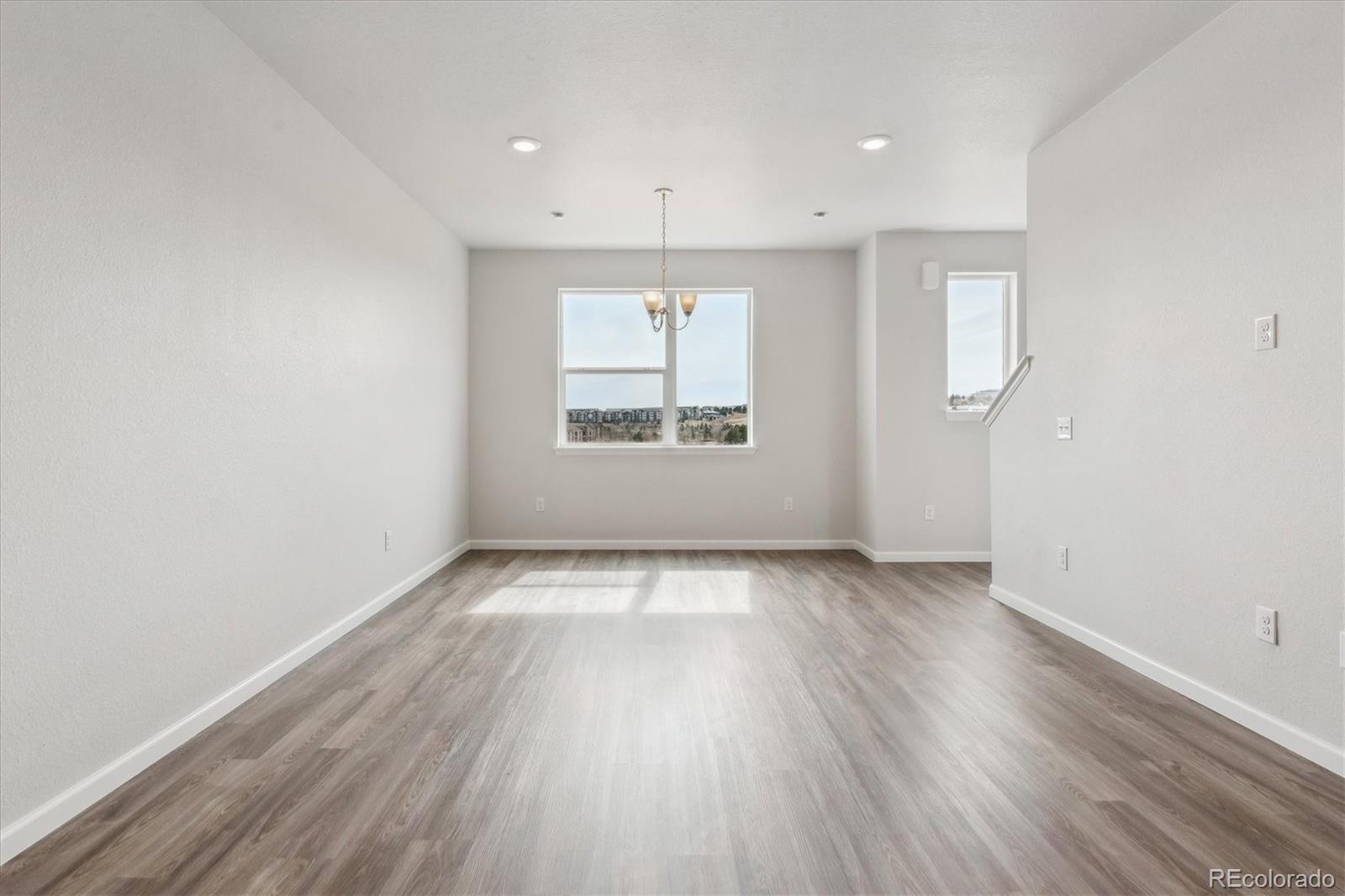 453 Interlocken Boulevard, Unit 103 Broomfield, CO 80021 - Photo 2 of 15 an empty room with wooden floor and windows
