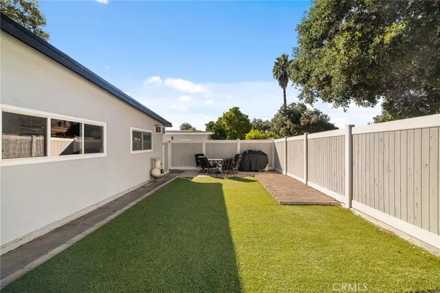 a view of a house with backyard and sitting area