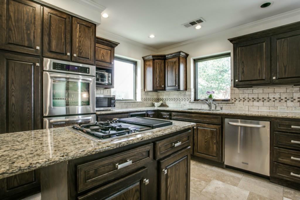 5419 Merrimac Avenue Dallas, TX 75206 - Photo 10 of 17 Kitchen featuring wood cabinetry, stainless steel appliances, granite countertops, tile backsplash, and a gas cooktop on the island