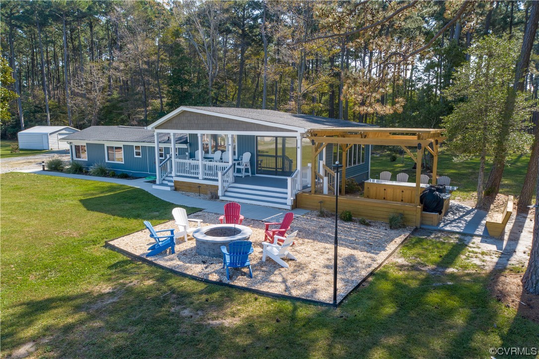 215 Riverside Drive Deltaville, VA 23043 - Photo 1 of 49 a view of a house with backyard sitting area and garden