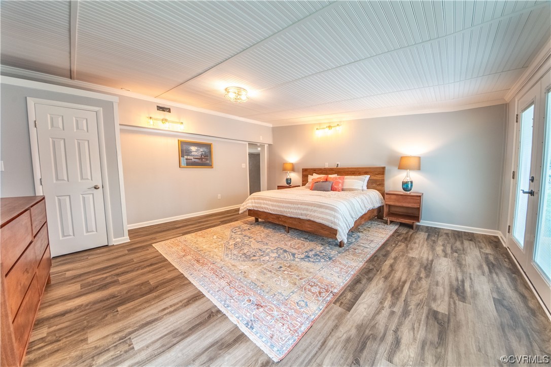 215 Riverside Drive Deltaville, VA 23043 - Photo 17 of 49 a bedroom with a large bed and a wooden floor