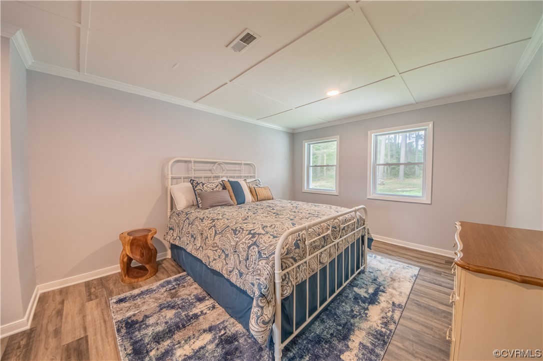 215 Riverside Drive Deltaville, VA 23043 - Photo 27 of 49 a bedroom with a bed and wooden floor