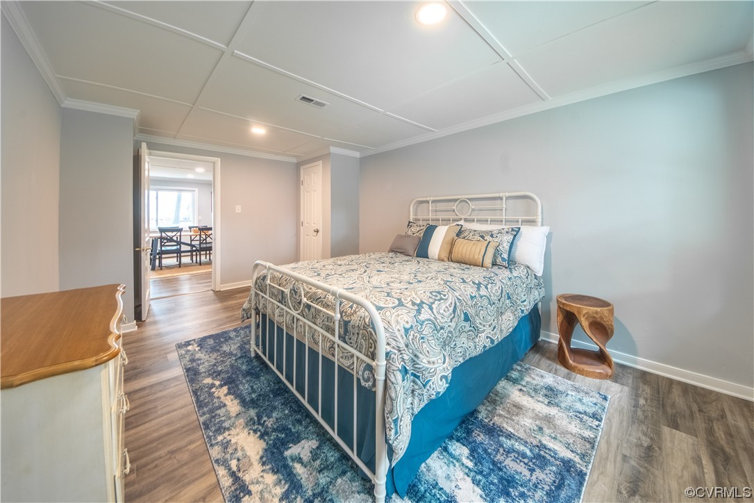 215 Riverside Drive Deltaville, VA 23043 - Photo 28 of 49 a bedroom with a bed and wooden floor