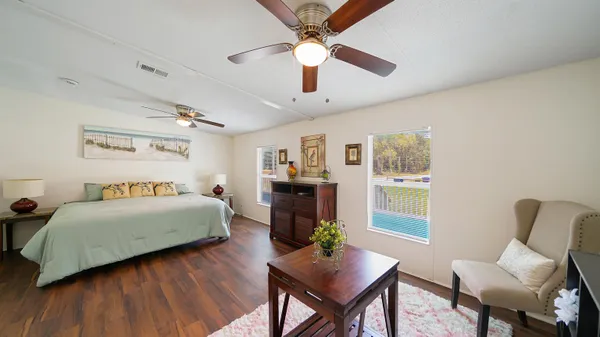 a bedroom with a bed wooden floor and window