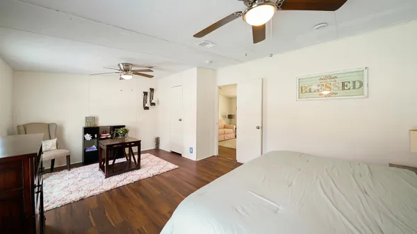 a bedroom with a bed chandelier and a window