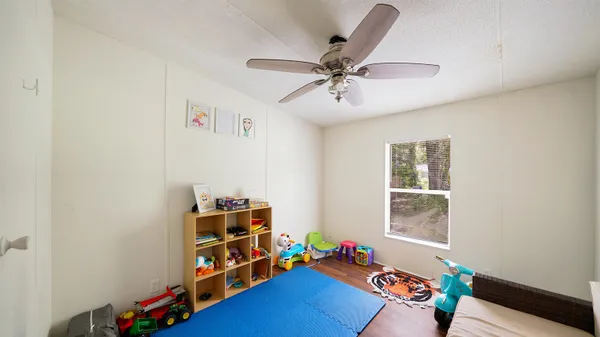 a living room with baby crib furniture and a window