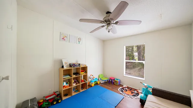 a living room with baby crib furniture and a window