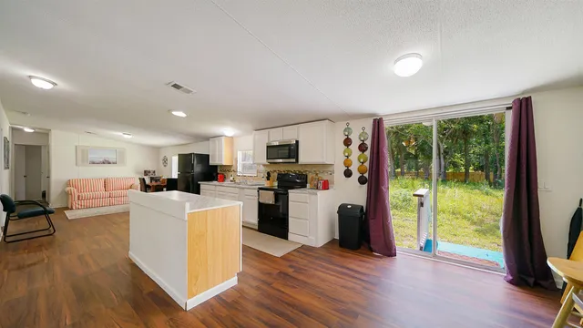 a living room with furniture a flat screen tv and a floor to ceiling window
