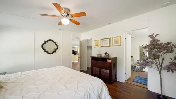 a bedroom with a bed and wooden floor
