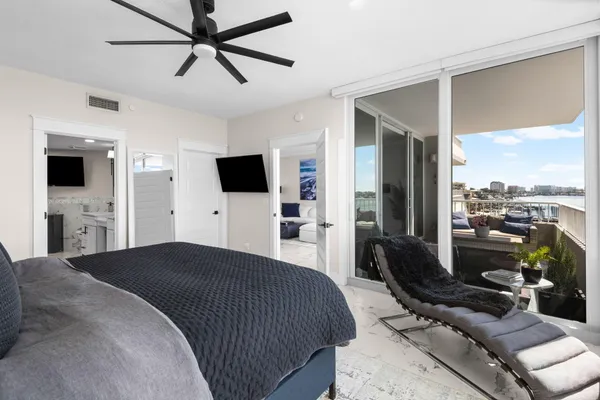 a bedroom with a bed and a flat tv screen on dresser