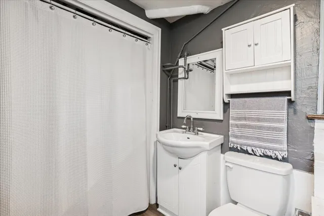 a bathroom with a sink a toilet and a mirror